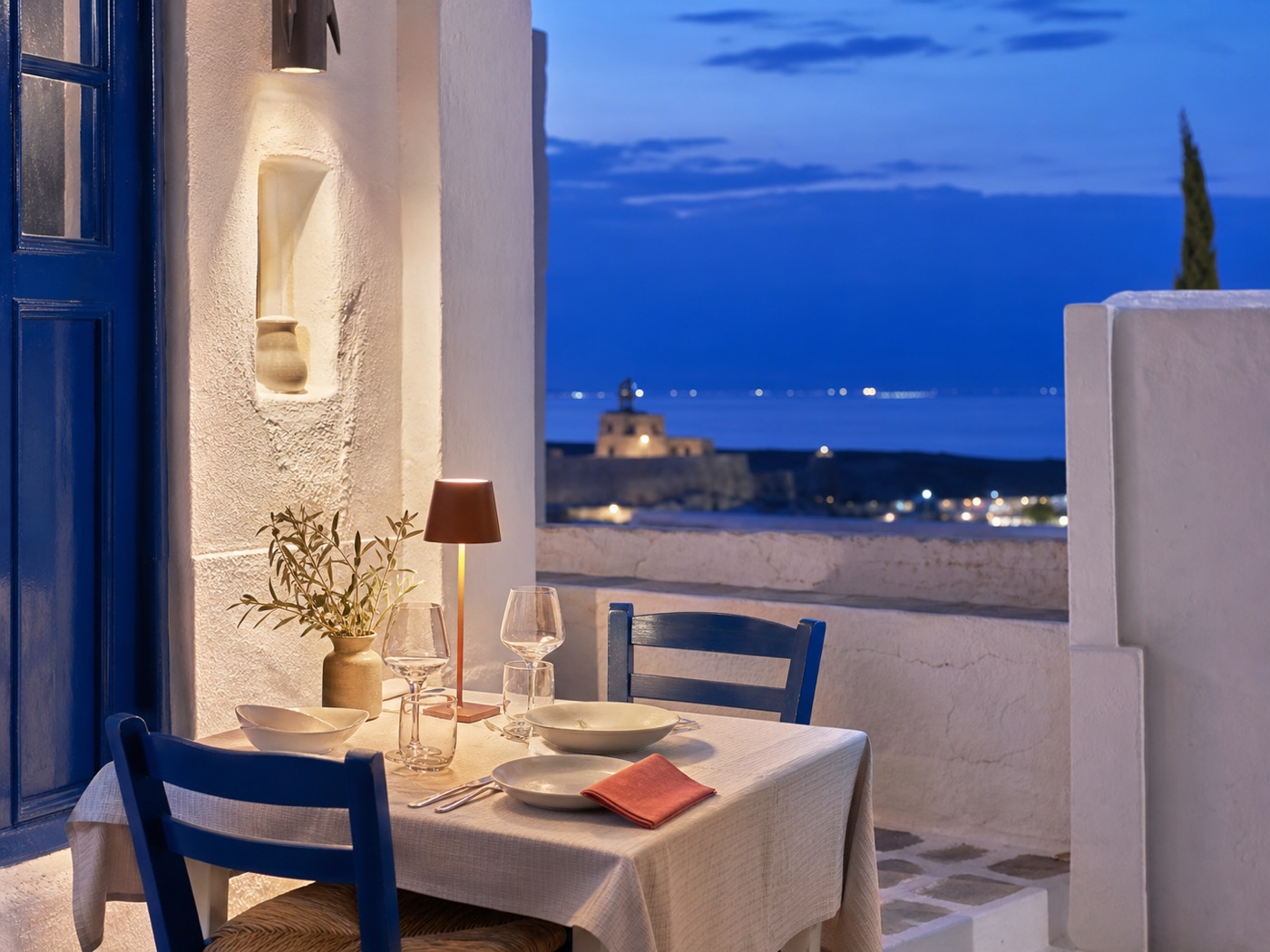 Blue-hour terrace setting with sea-facing tables