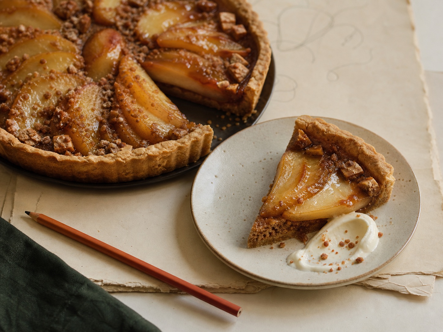 Pear tart served with a spoonful of cream
