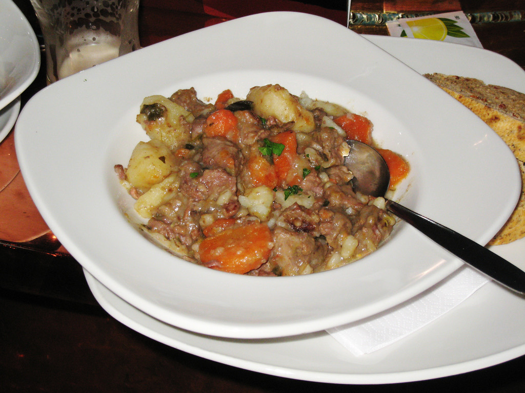 Bowl of Irish stew with vegetables and herbs