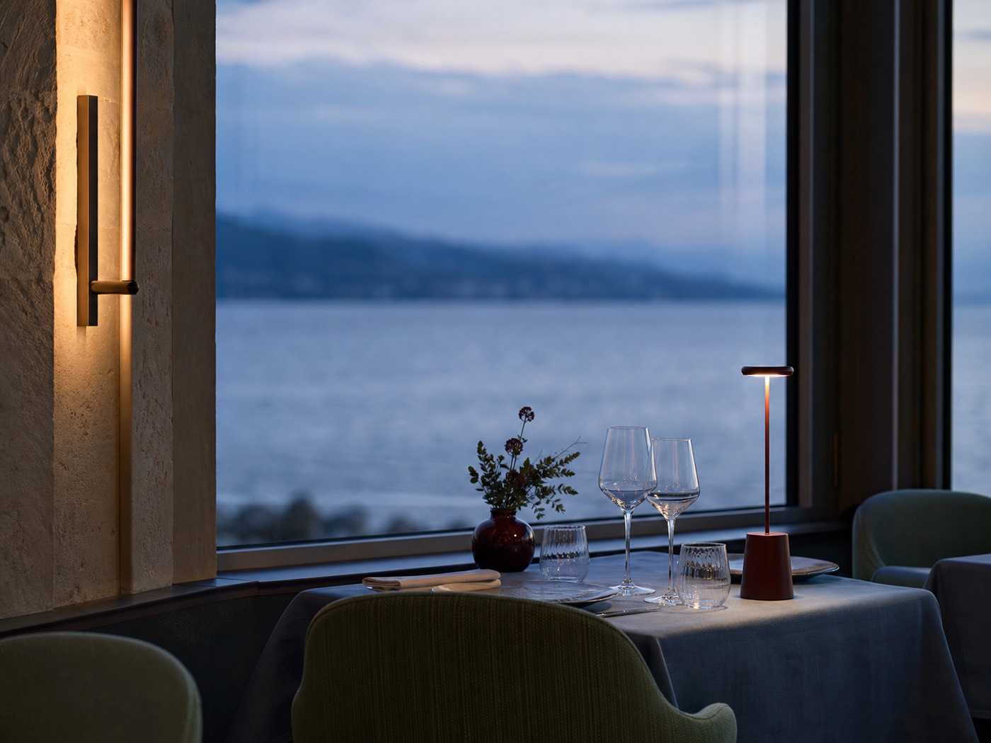 Evening table beside a large window with a water horizon